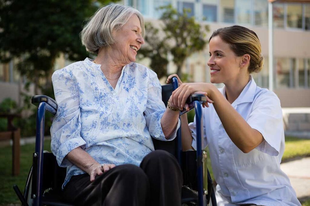 Older adult and family caregiver reviewing a respite stay plan in a bright assisted living room.